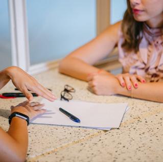 Pen and paper on table between two women